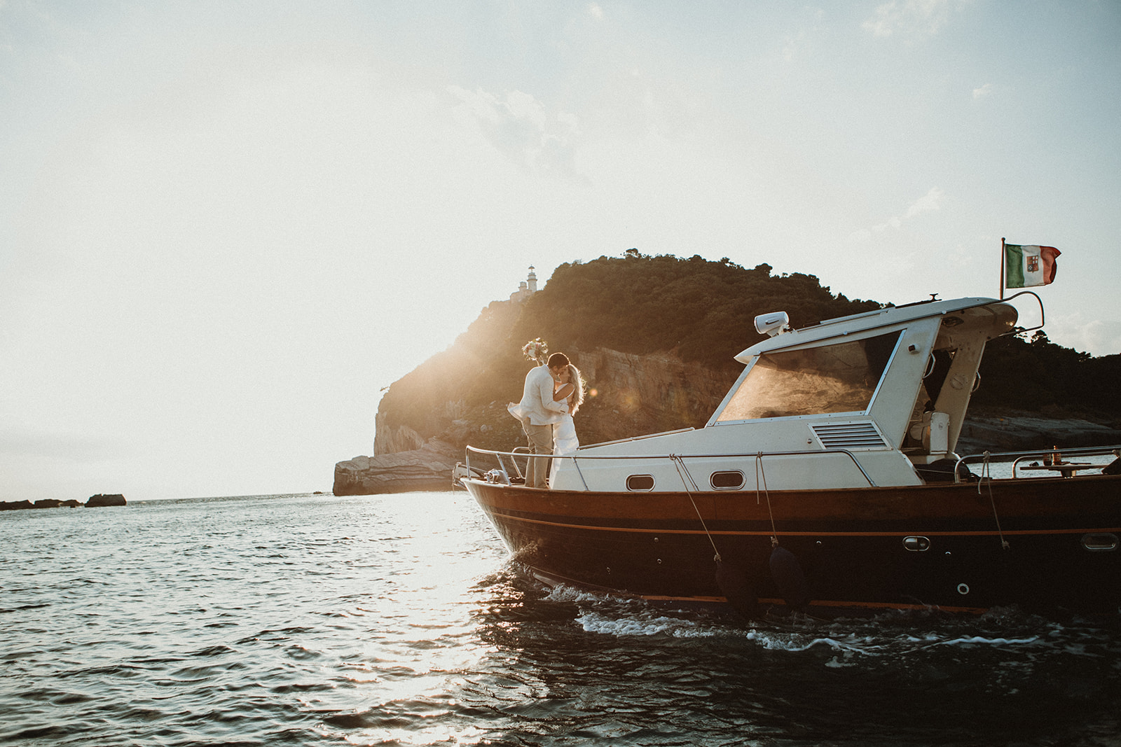 Couple kissing on a boast at sunset with the most dramatic light during their elopement in Cinque Terre