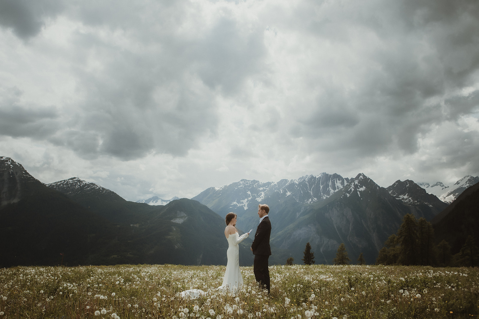 Couple exchanging their vows on a flowery meadow in the Italian Alps