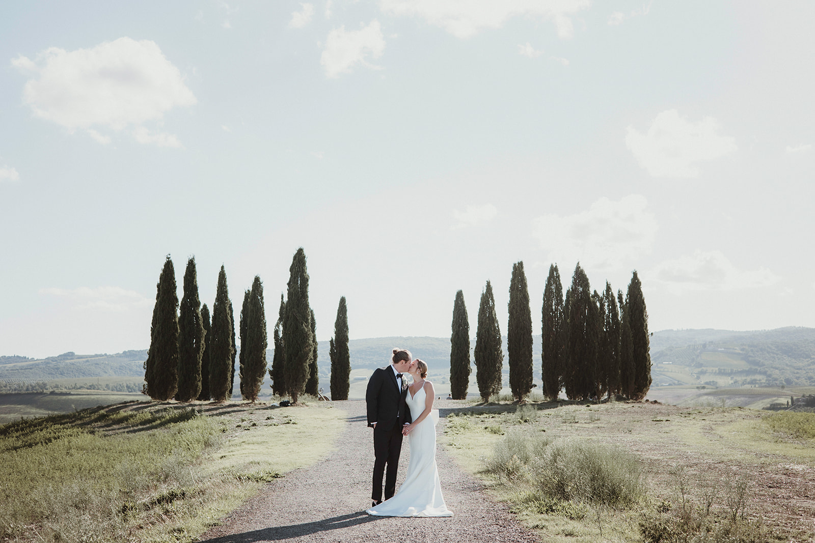 Couple kissing in front of Cipressi di San Quirico during their elopement in Tuscany