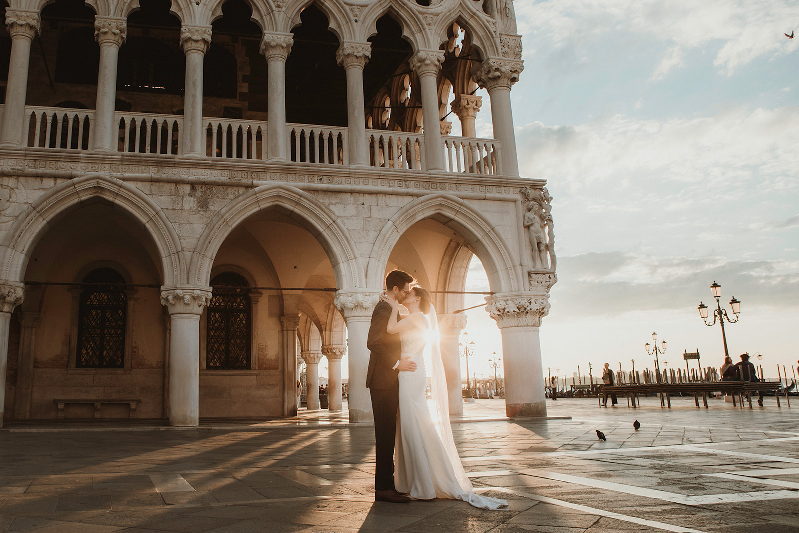 Couple kissing with the most dramatic light at dawn for their sunrise elopement in Venice