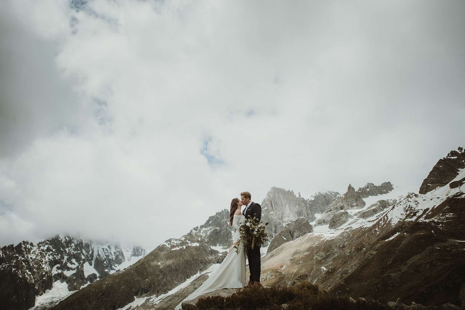 Couple kissing together on a mountain ridge in the Italian Alps during an intimate elopement.