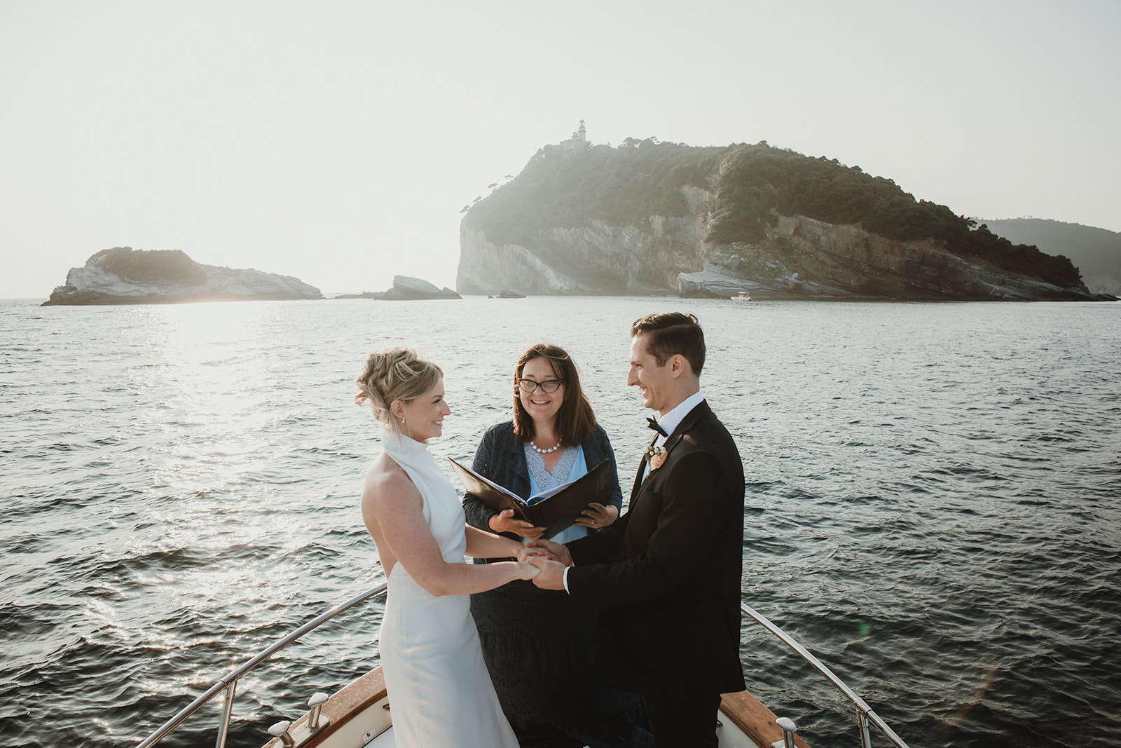 Couple having their symbolic ceremony on a boat at sunset during their elopement in Cinque Terre
