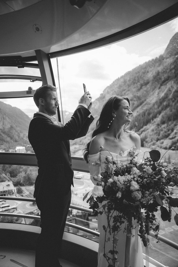 Couple admiring panoramic views of Mont Blanc from inside the rotating Skyway cable car during their Italy mountain elopement.