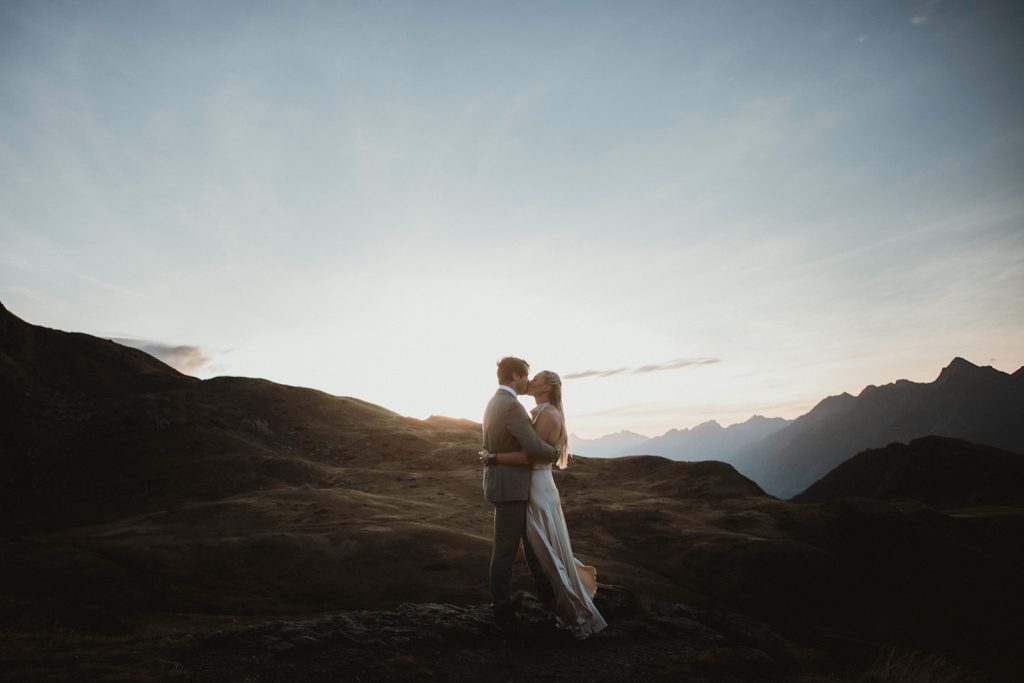 Holly & Loz kissing after exchanging vows at sunrise on a mountain in the Italian Alps, intimate mountain elopement