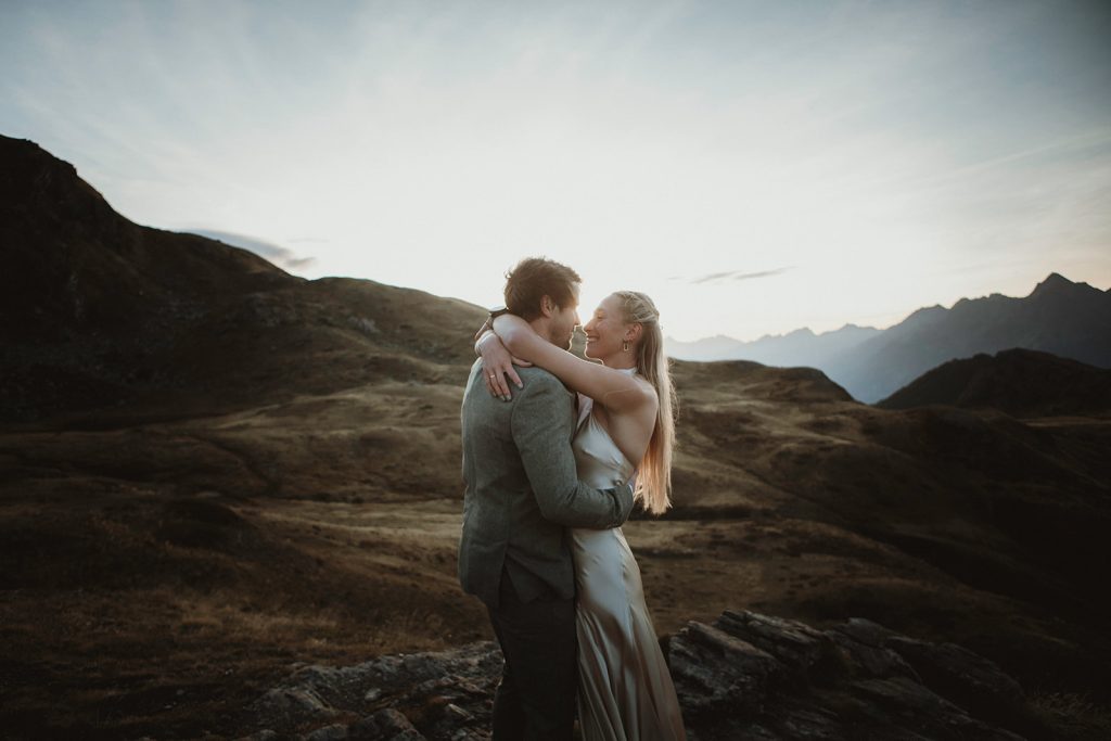 Couple embracing at sunrise in the Aosta Valley mountains during an adventure elopement in Italy