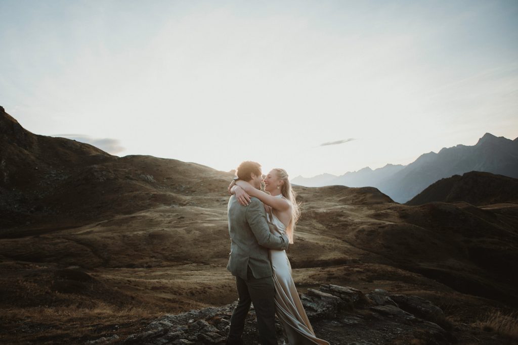 Couple embracing at sunrise in the Aosta Valley mountains during an adventure elopement in Italy