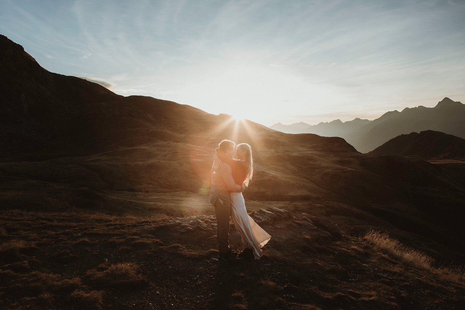 Couple embracing at sunrise in the Aosta Valley mountains during an adventure elopement in Italy
