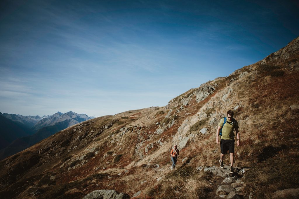 Couple hiking to a hidden alpine lake in the Aosta Valley for adventure elopement photos
