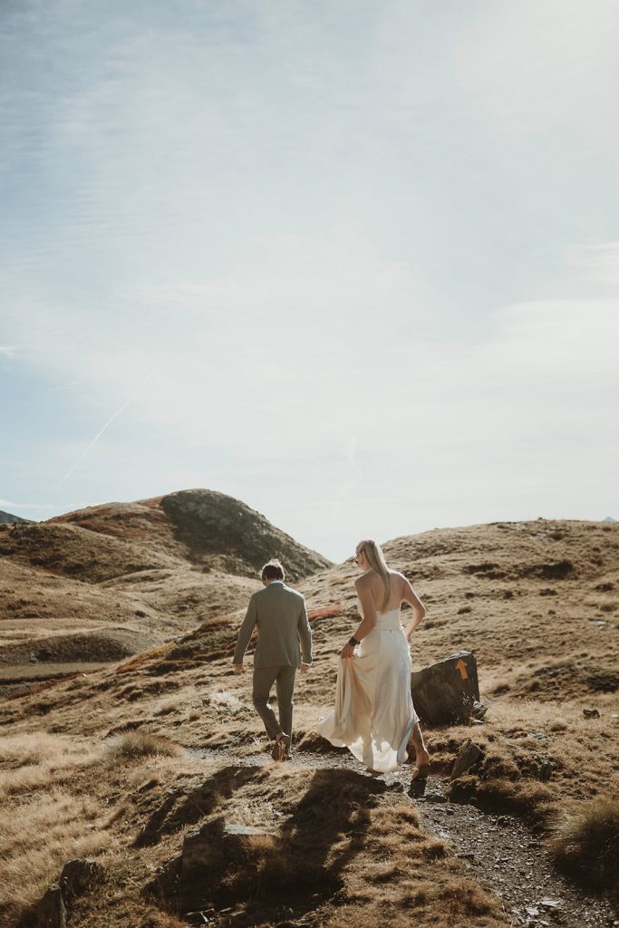 Couple hiking to a hidden alpine lake in the Aosta Valley for adventure elopement photos