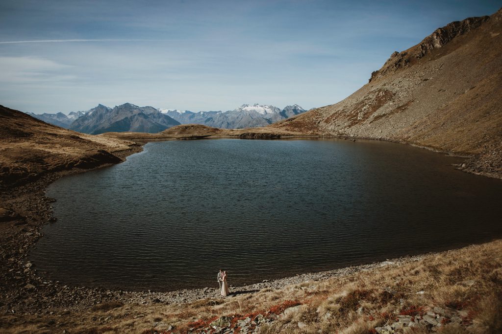 Adventure elopement Italy: couple photographed by a secluded lake in the Aosta Valley, Italian Alp
