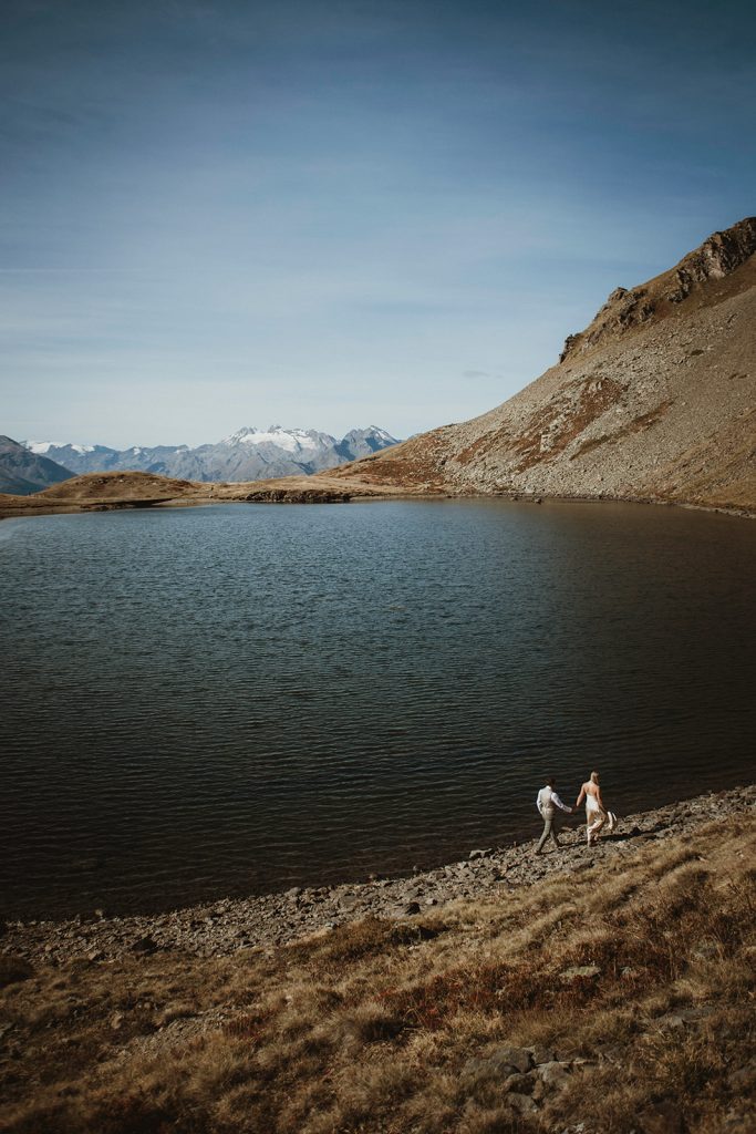 Adventure elopement Italy: couple photographed by a secluded lake in the Aosta Valley, Italian Alp