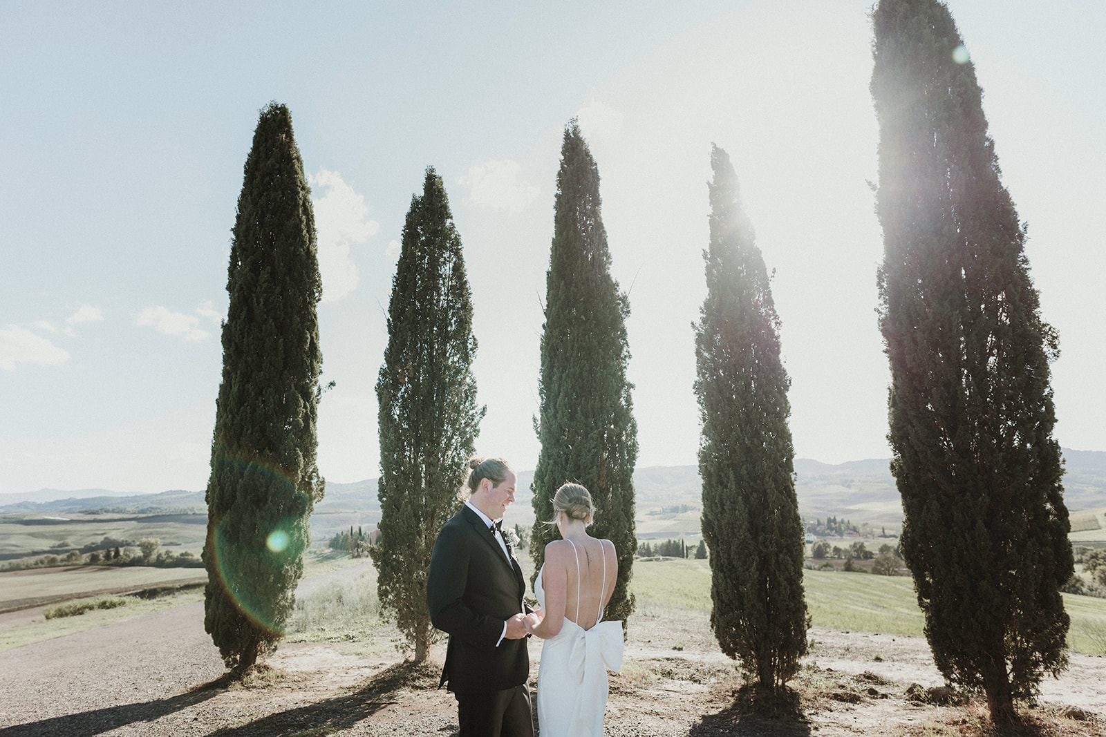 Couple exchanging vows among cypresses on their elopement in Tuscany