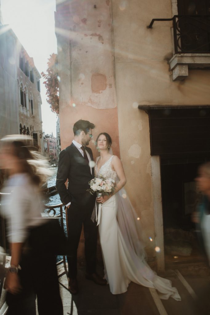 Couple posing with a Venice canal in the background on their elopement day