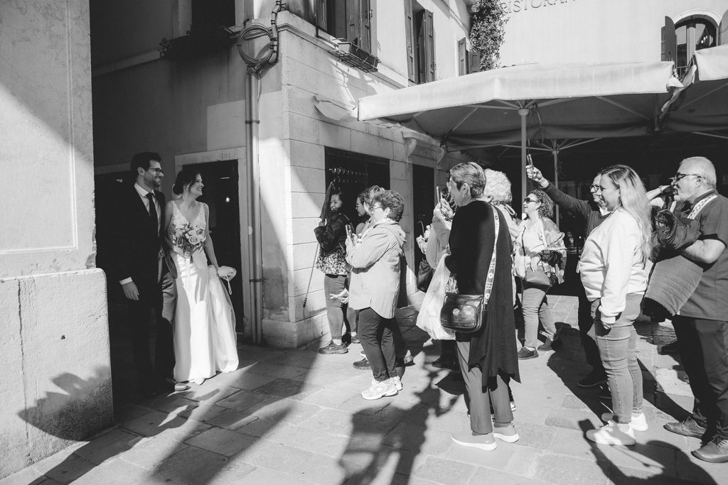 Couple being cheered by the crowds on their elopement in Venice