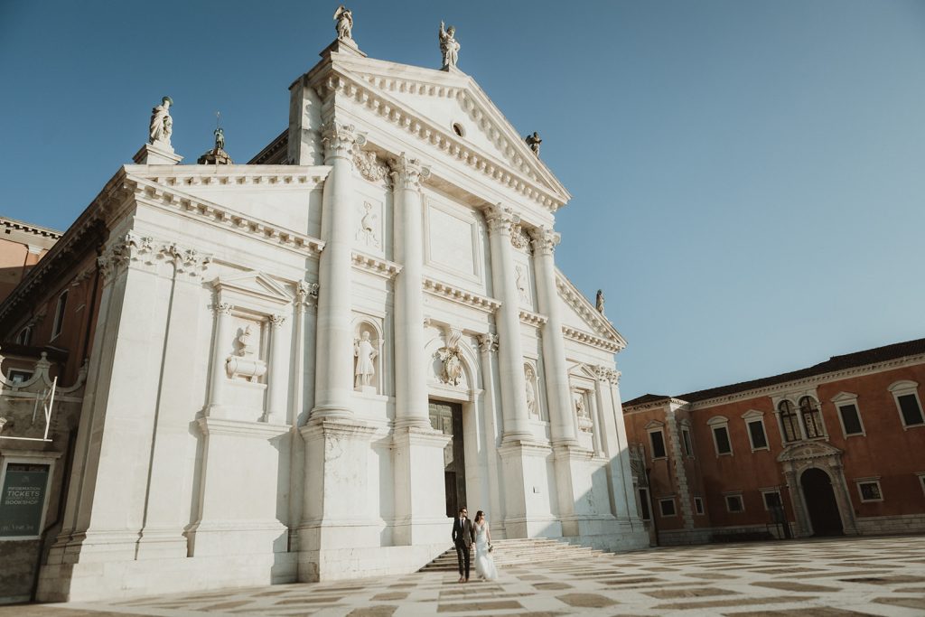 Architecture picture with couple on their elopement day in Venice as they walk in San Giorgio