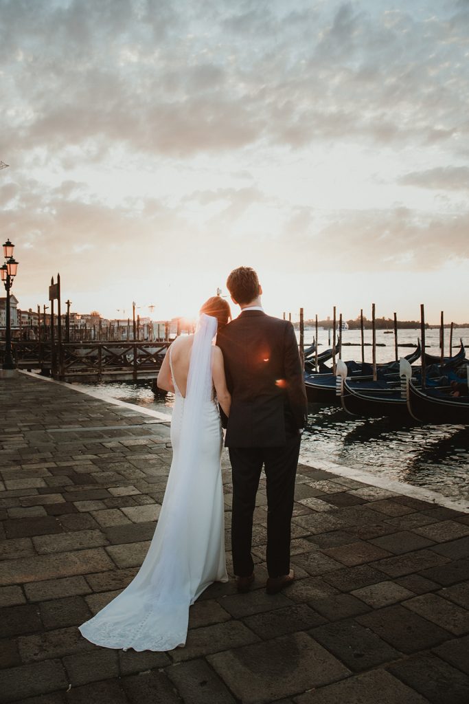 Couple enjoying the first morning light on their sunrise elopement in Venice