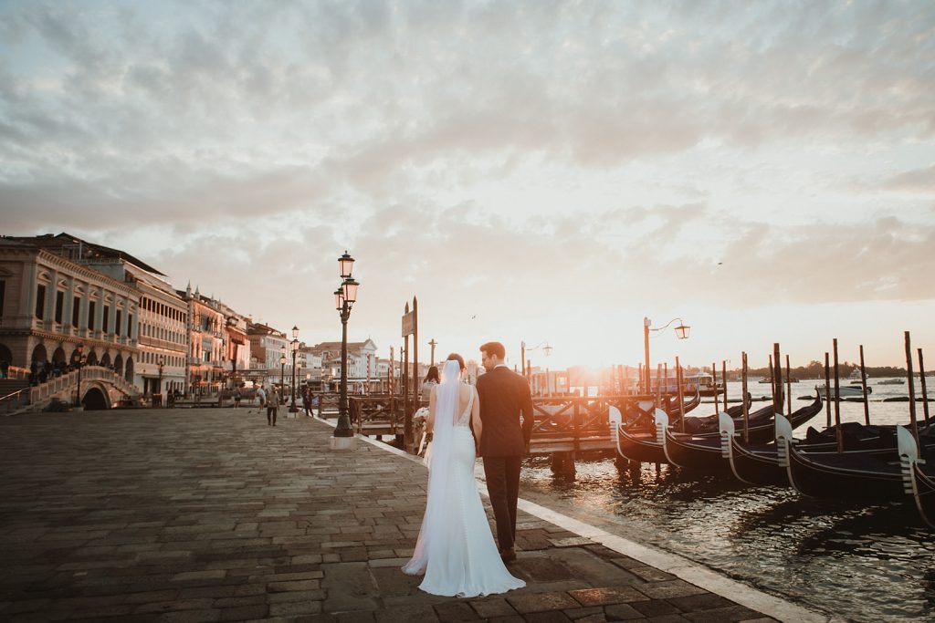 Couple photoshoot at dawn with views of gondolas and water on a Venice Elopement