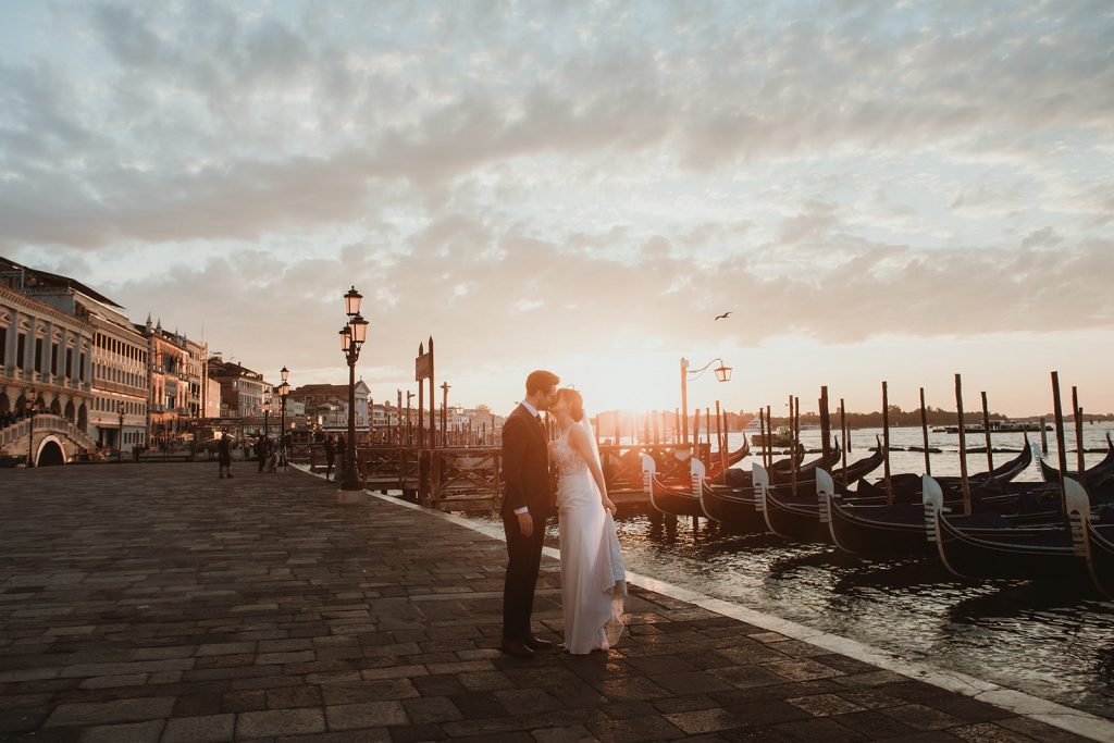 Couple photoshoot at dawn with views of gondolas and water on a Venice Elopement