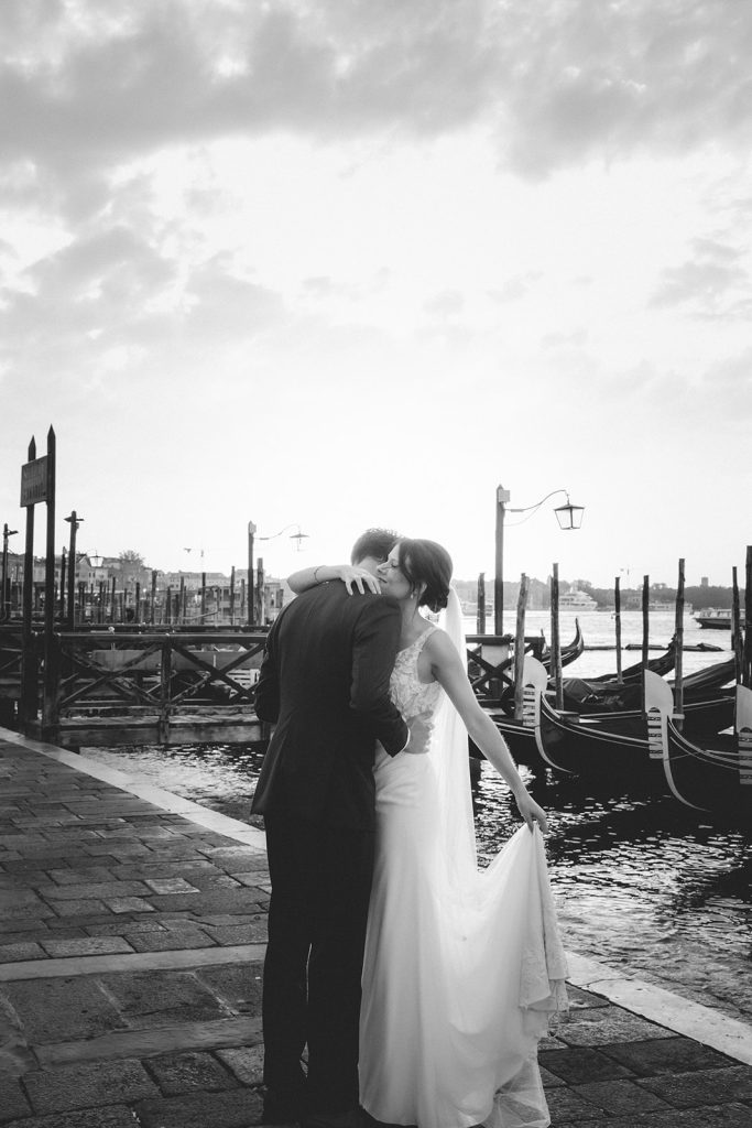 Couple photoshoot at dawn with views of gondolas and water on a Venice Elopement