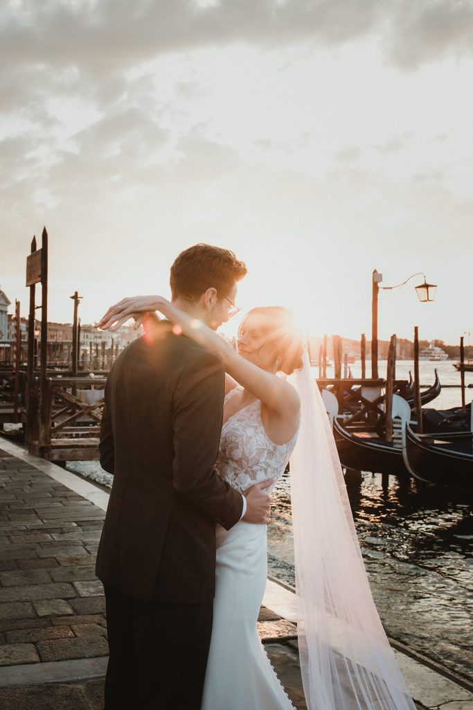 Couple photoshoot at dawn with views of gondolas and water on a Venice Elopement