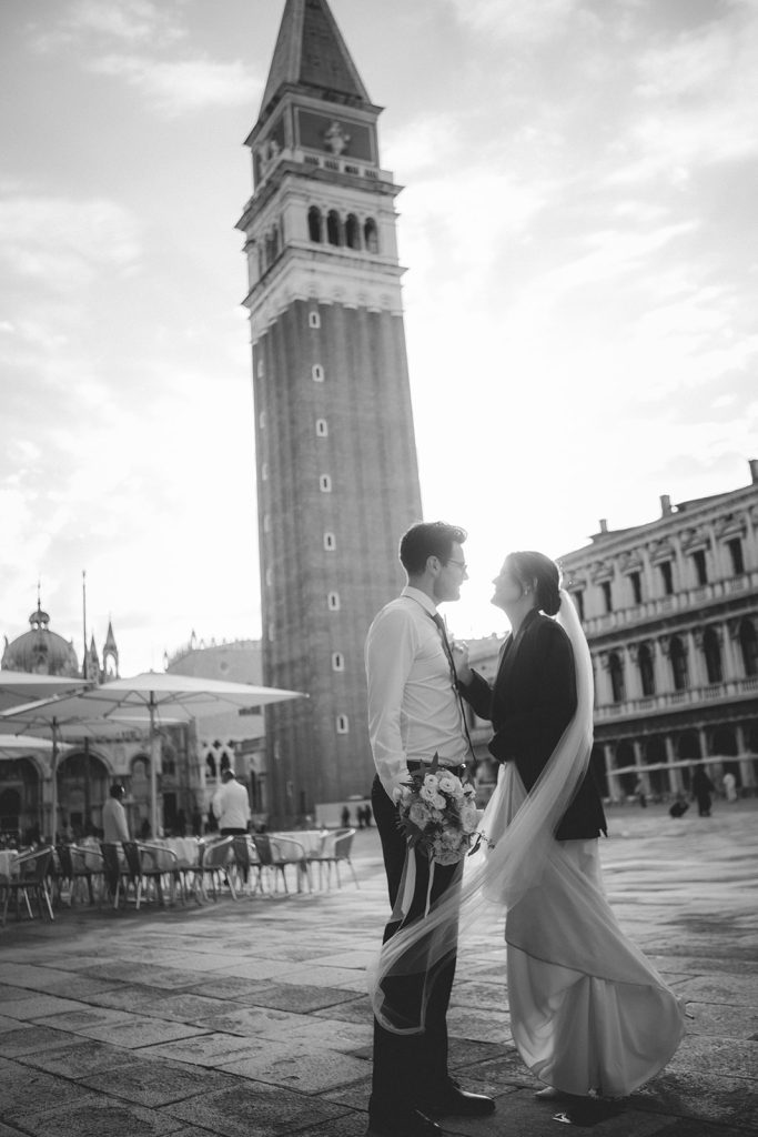 Couple dancing happily in Piazza San Marco as the first morning light hits the buildings