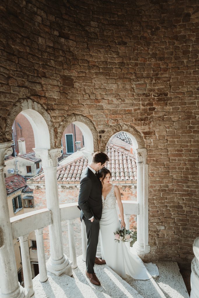 Couple posing on the stairs of Palazzo Contarini del Bovolo on their elopement in Venice