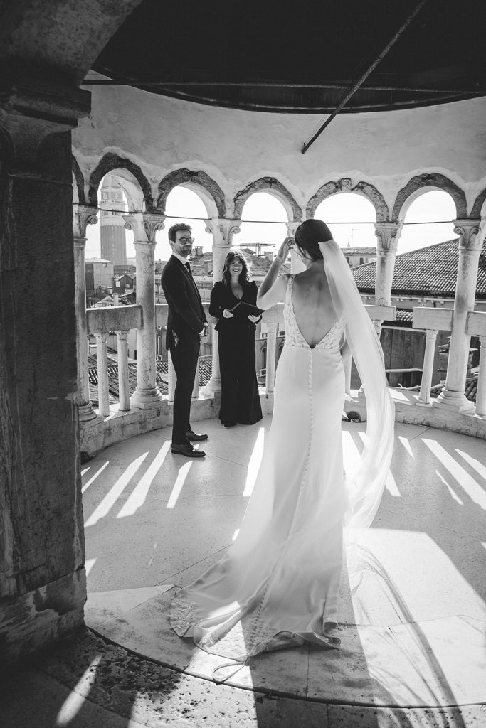 Bride walking towards groom as they are about to start their elopement ceremony in Venice