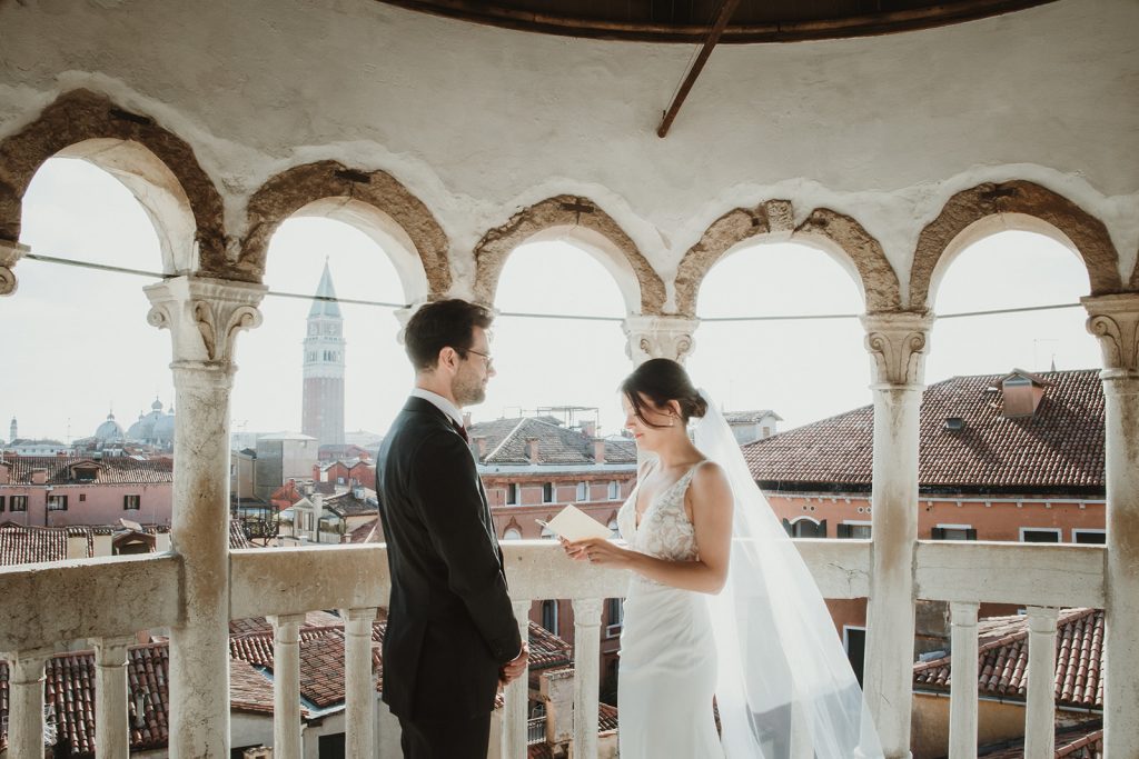 Couple exchanging vows during their intimate symbolic ceremony at Palazzo Contarini del Bovolo on their elopement in Venice