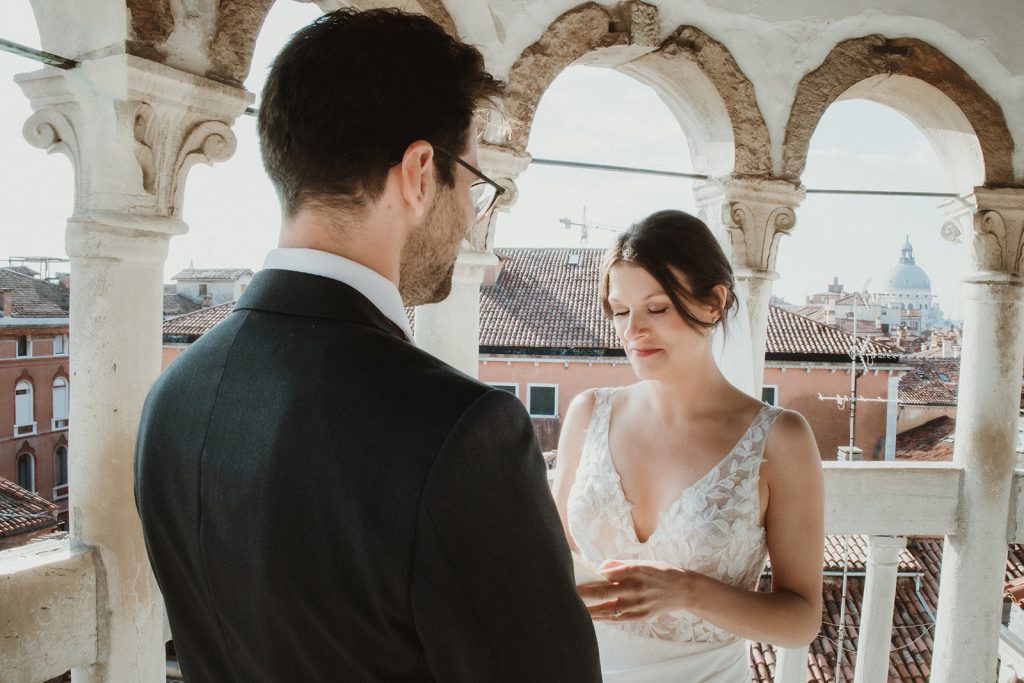 Couple exchanging vows during their intimate symbolic ceremony at Palazzo Contarini del Bovolo on their elopement in Venice
