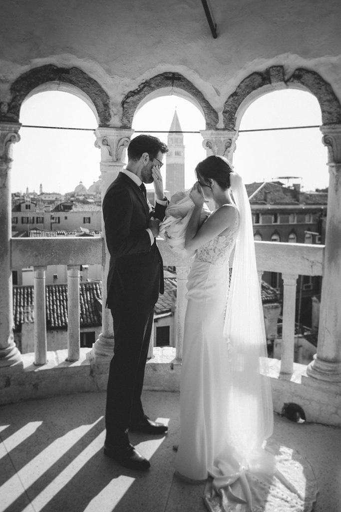 Couple getting emotional and drying their tears as they get married at Palazzo Contarini del Bovolo in Venice