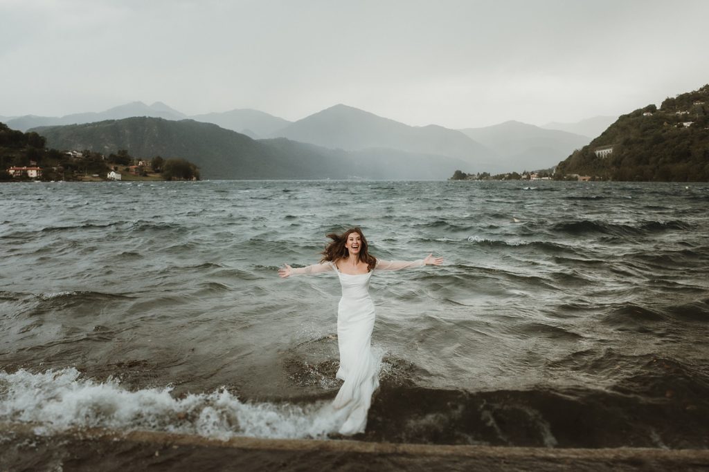 Bride getting into a stormy lake for a trash the dress moment in Northern Italy