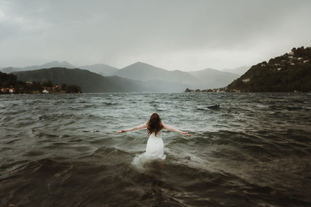 bride trashing her dress in a stormy lake in Northern Italy