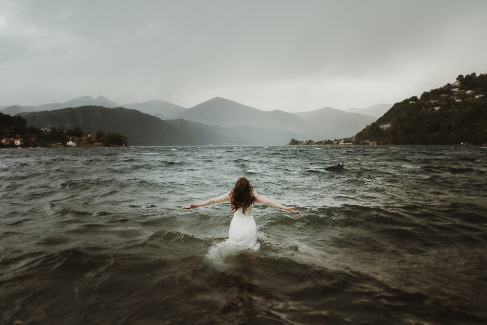 bride trashing her dress in a stormy lake in Northern Italy