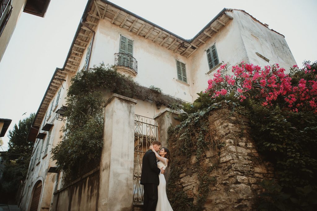 Couple embracing in front of a typical Italian house on their elopement in Italy