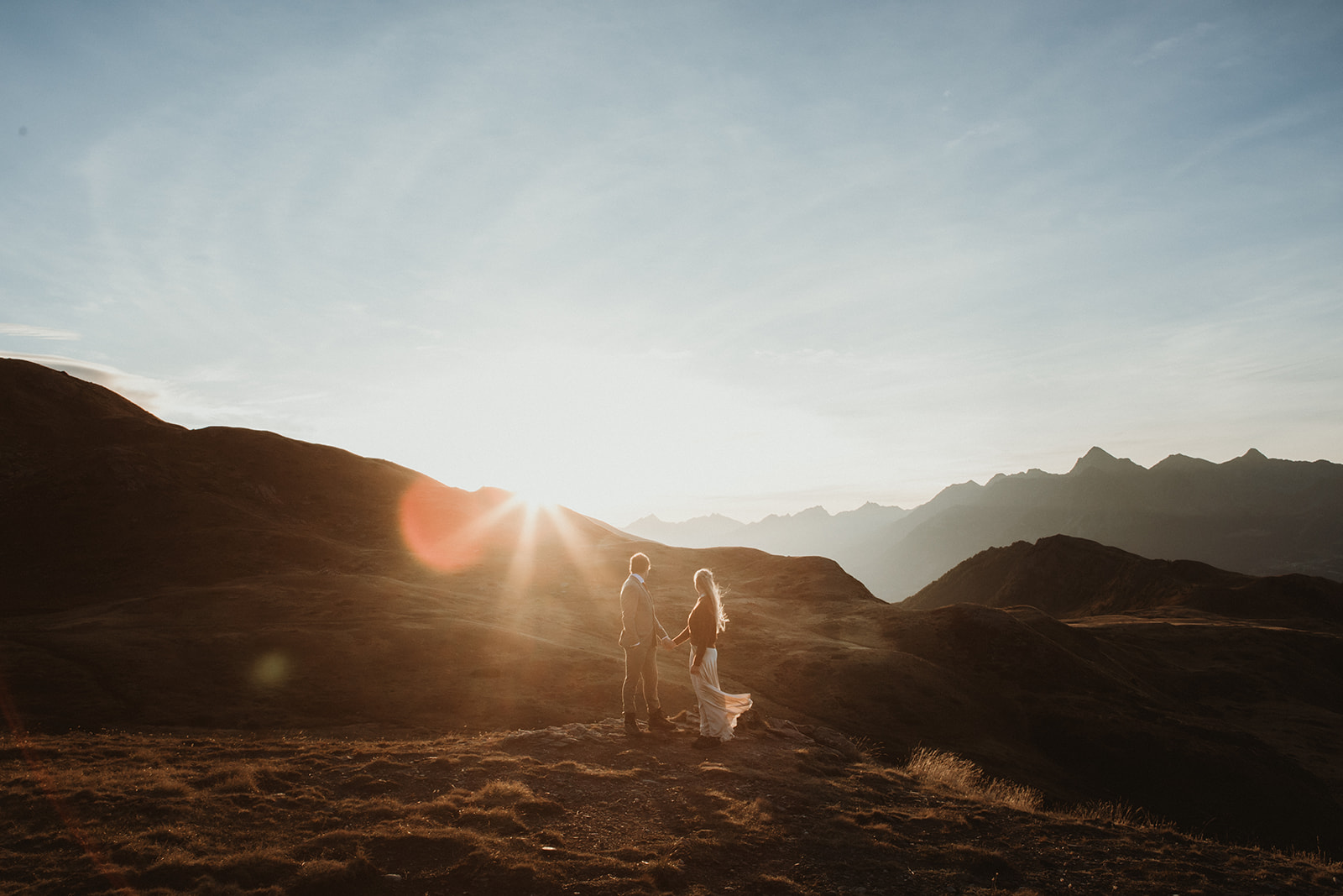 Couple watching sunrise on their epic elopement in the Italian Alps
